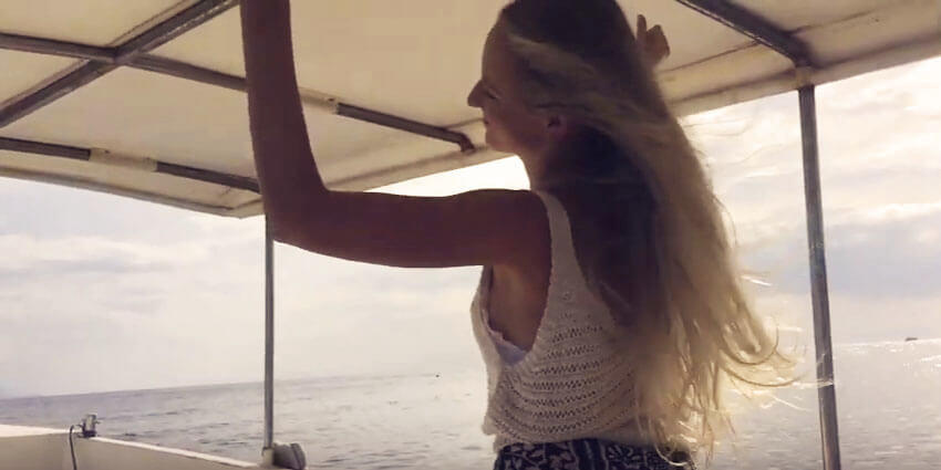 santosha yoga teacher training student dancing on boat