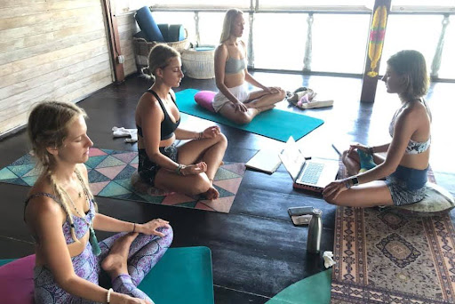 Yoga participants seated calmly in lotus position during group meditation